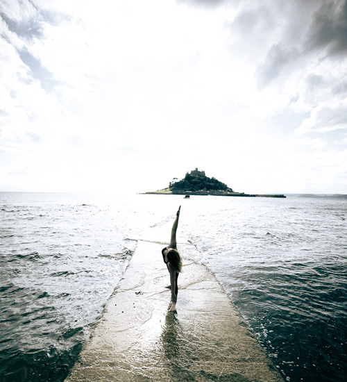 Woman doing trikonasana in the sea