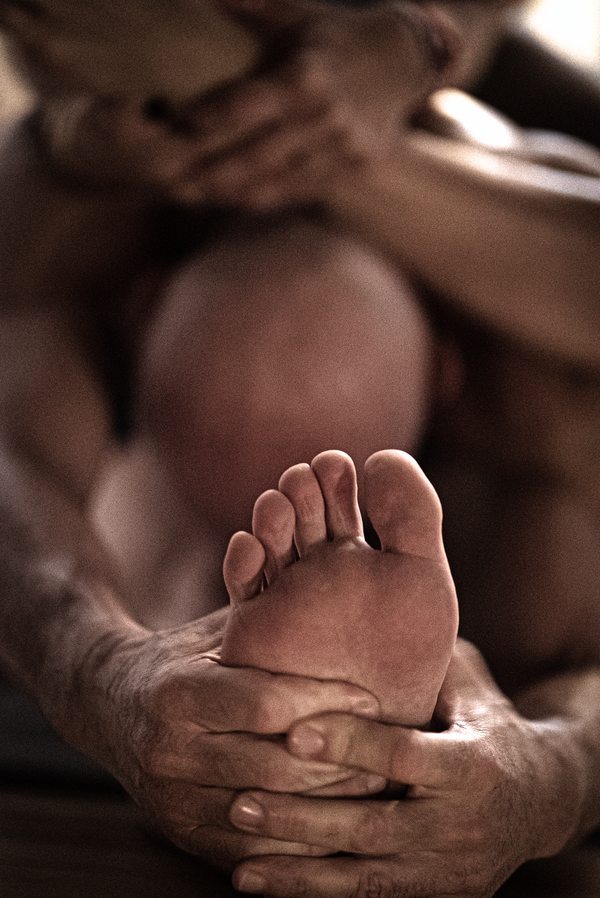 A man's foot is being held by another person during Daniele Morganti's Ashtanga workshop in Barcelona in November 2023.