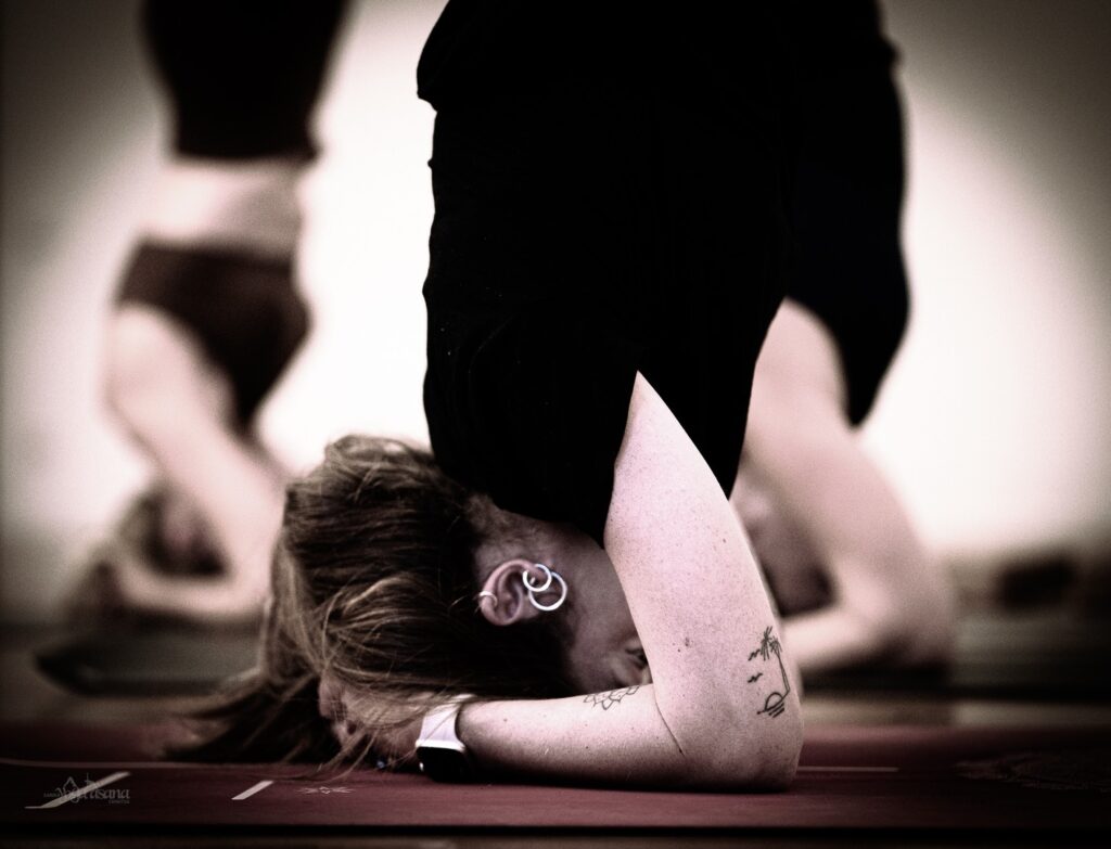 A woman doing a handstand on a yoga mat.