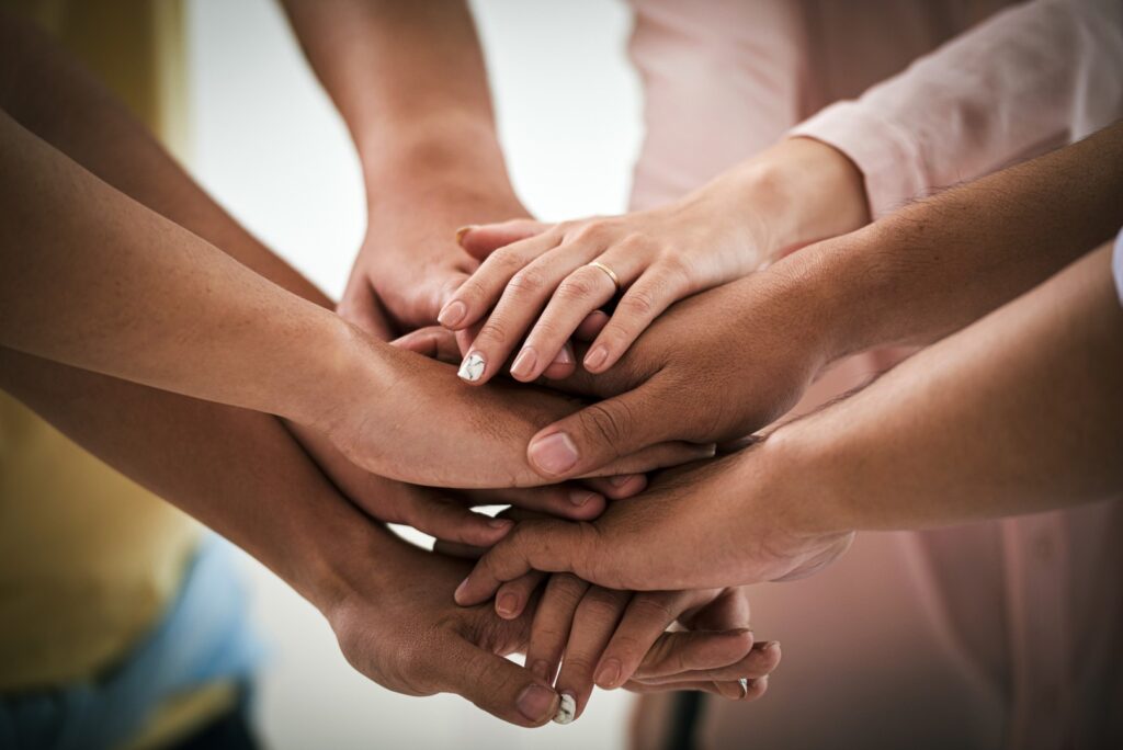A group of people putting their hands together.