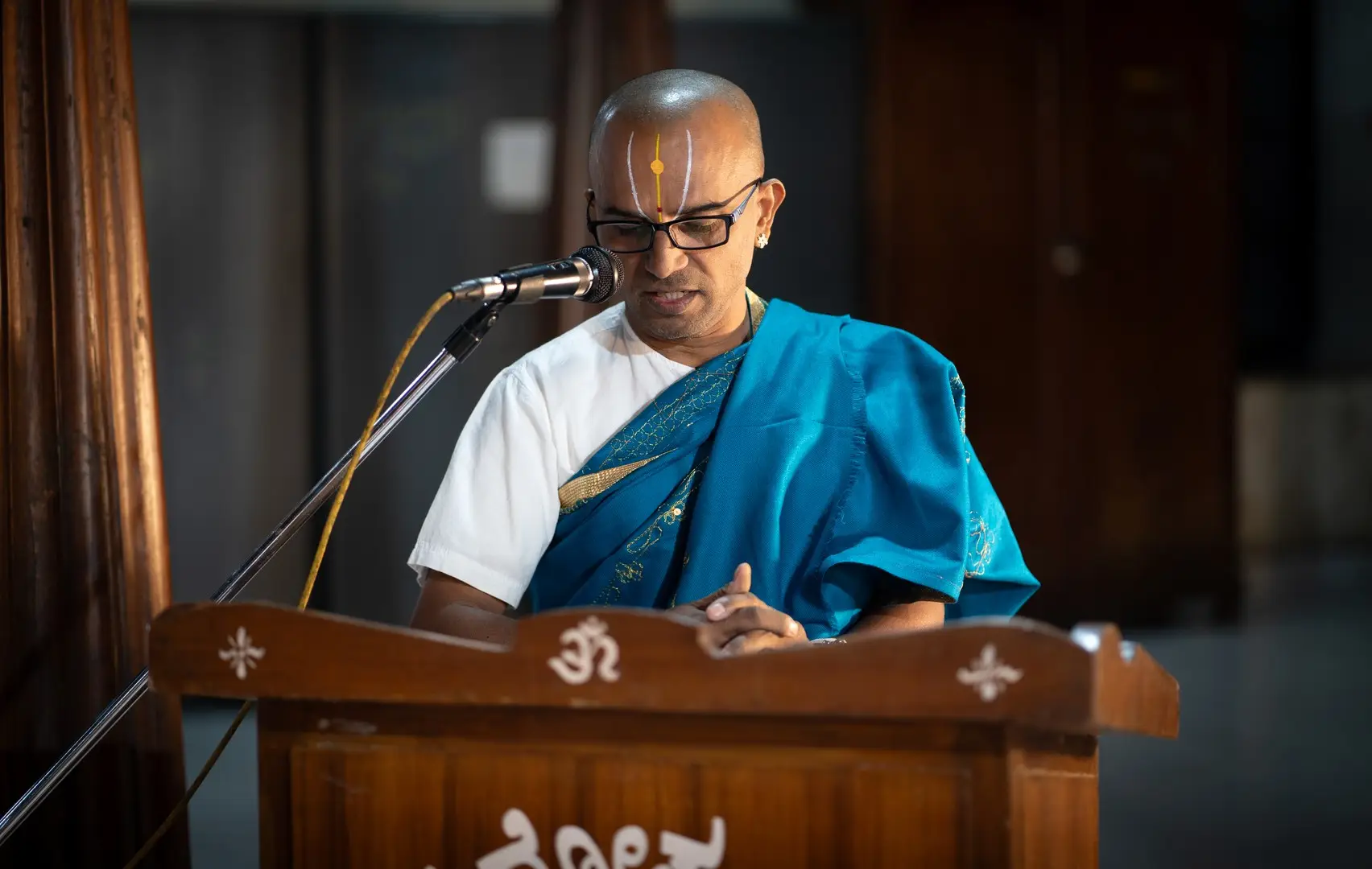Man speaking at podium sanskrit