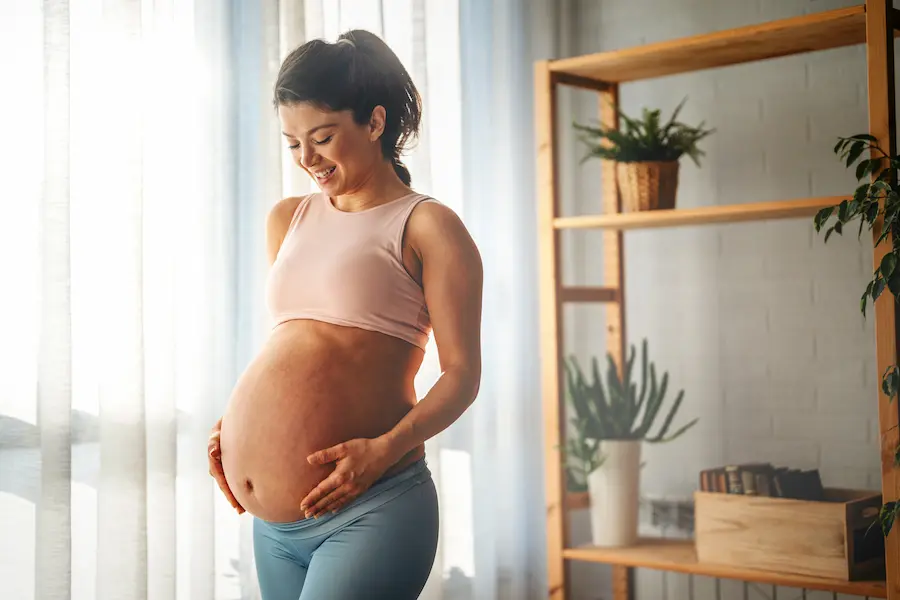 Mujer embarazada sonriendo felizmente